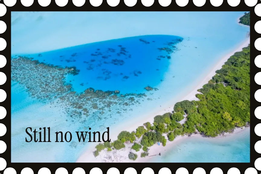 A postcard: an aerial photograph of a lagoon in a black stamp frame, titled Still no wind.
